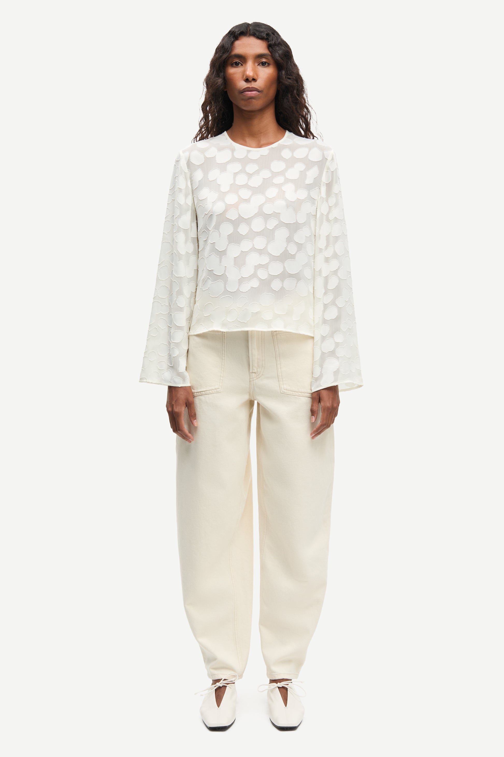 Front view of cream long sleeve top worn with cream trousers from Samsoe Samsoe