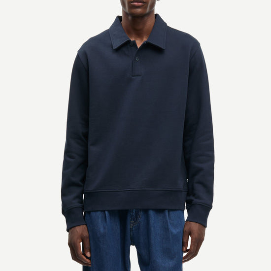 Man wearing a navy blue sweater and pants on a white background