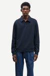 Man wearing a navy blue sweater and pants on a white background