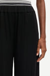 Black pants worn by a person on a white background