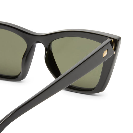 Black sunglasses by Le Specs on a white background close up