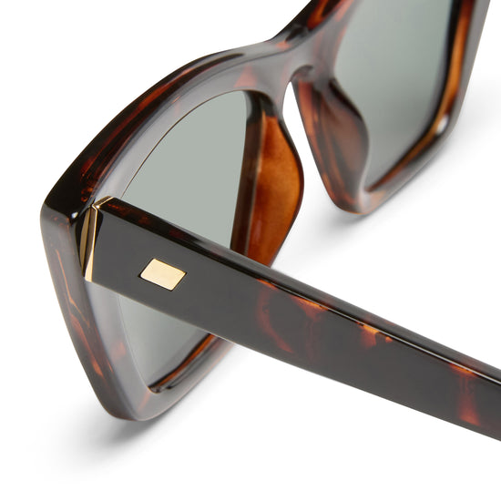 Tortoise shell Le Specs sunglasses on a white background close up