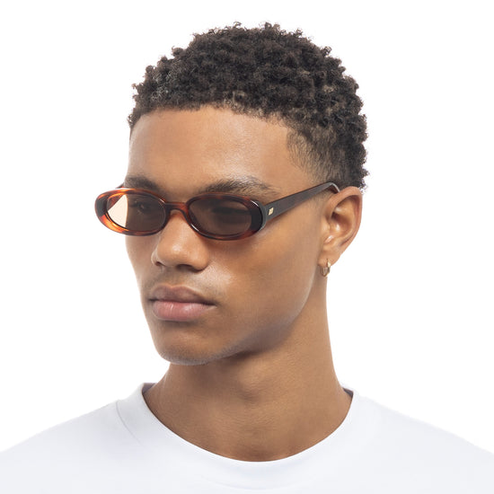 tortoise shell Le Specs sunglasses on a male model side view