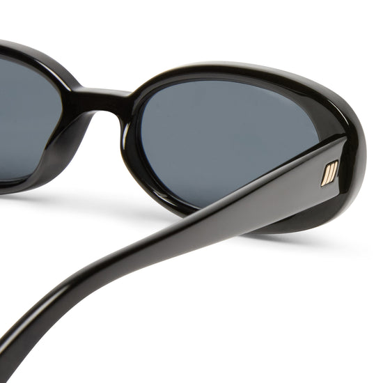 Black Le Specs Sunglasses on a white background close up