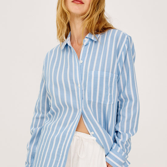 Woman wearing a blue and white Rails shirt striped shirt against a plain background