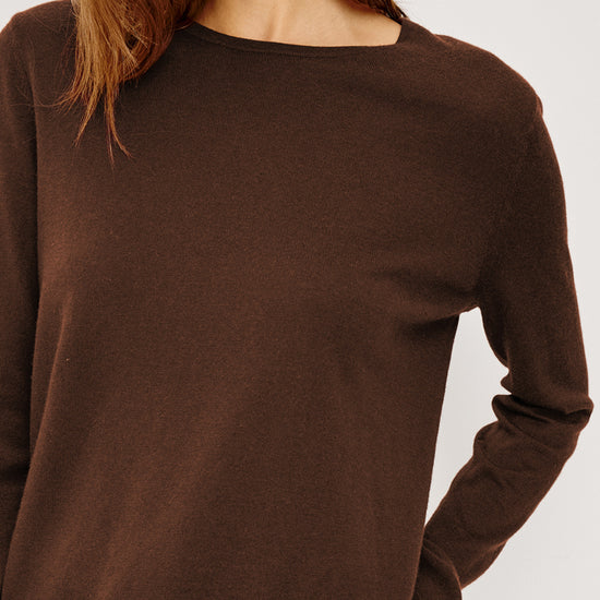 Brown sweater worn by a person on a white background