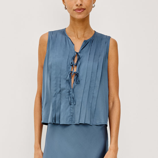 model wearing blue tie front sleeveless top with matching satin skirt 
