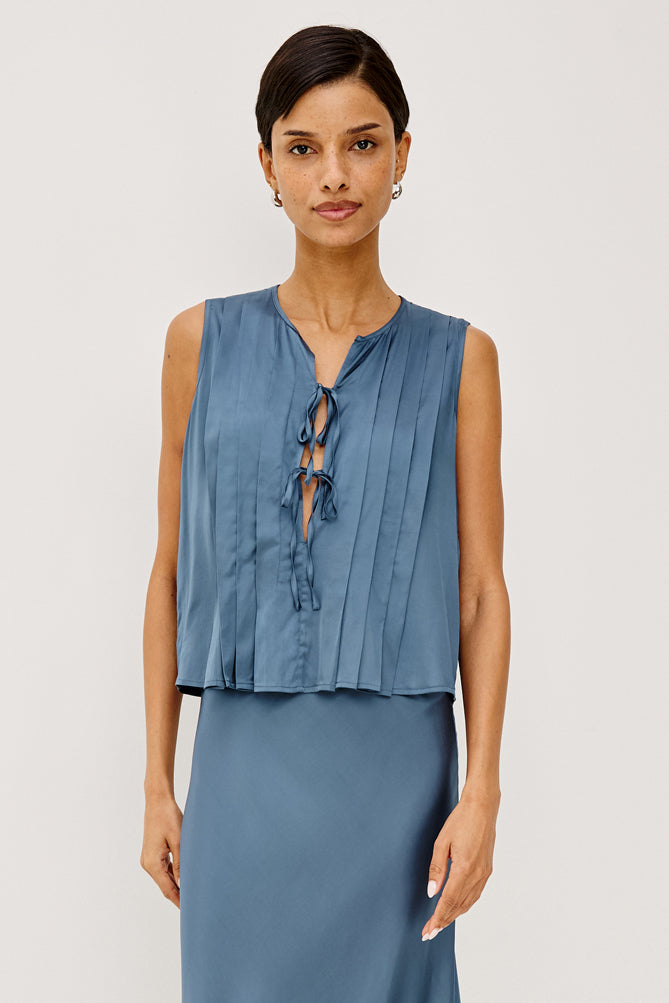 model wearing blue tie front sleeveless top with matching satin skirt 