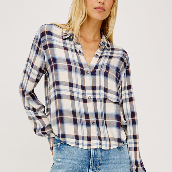 model wearing checkered short shirt with light blue denim jeans on a white background