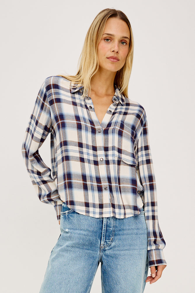 model wearing checkered short shirt with light blue denim jeans on a white background