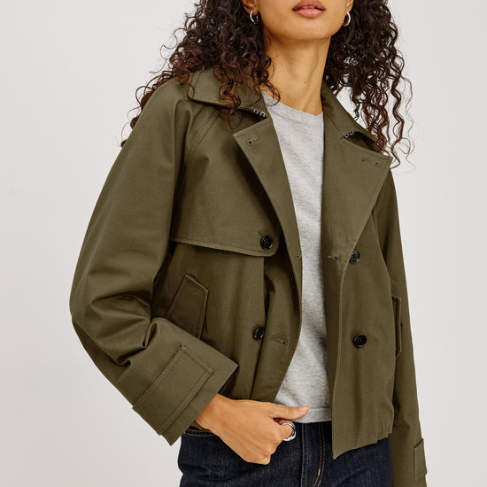 khaki green double breasted jacket worn with dark denim jeans 