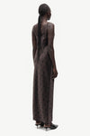 A model shown from the back wearing a dark brown sleeveless maxi dress with a subtle polka dot pattern, paired with black pointed-toe heels, against a plain light gray background.