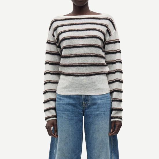 model wearing striped boat neck jumper and jeans on white background 