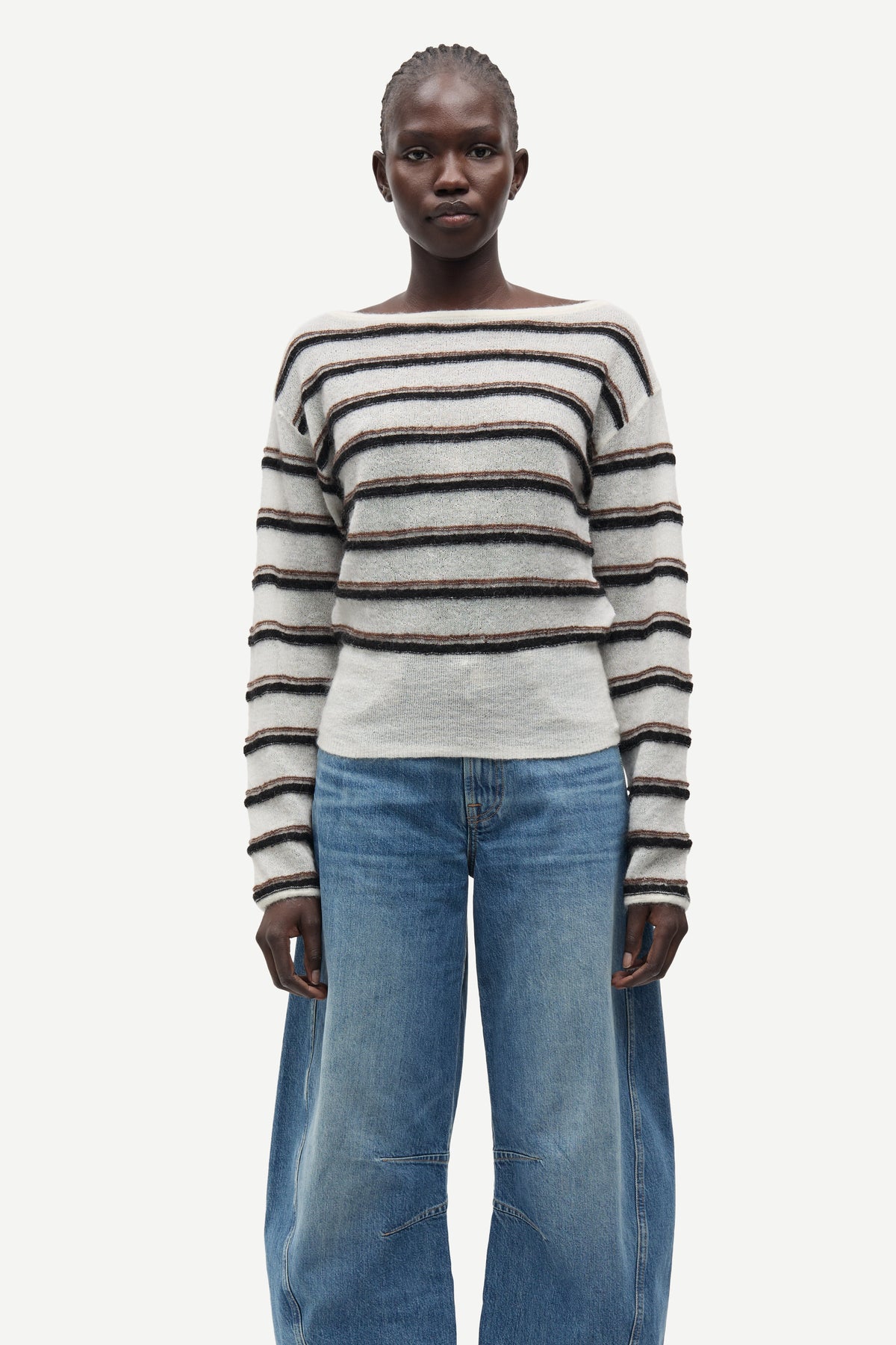 model wearing striped boat neck jumper and jeans on white background 