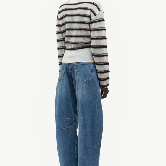 model wearing striped boat neck jumper and jeans on white background rear view