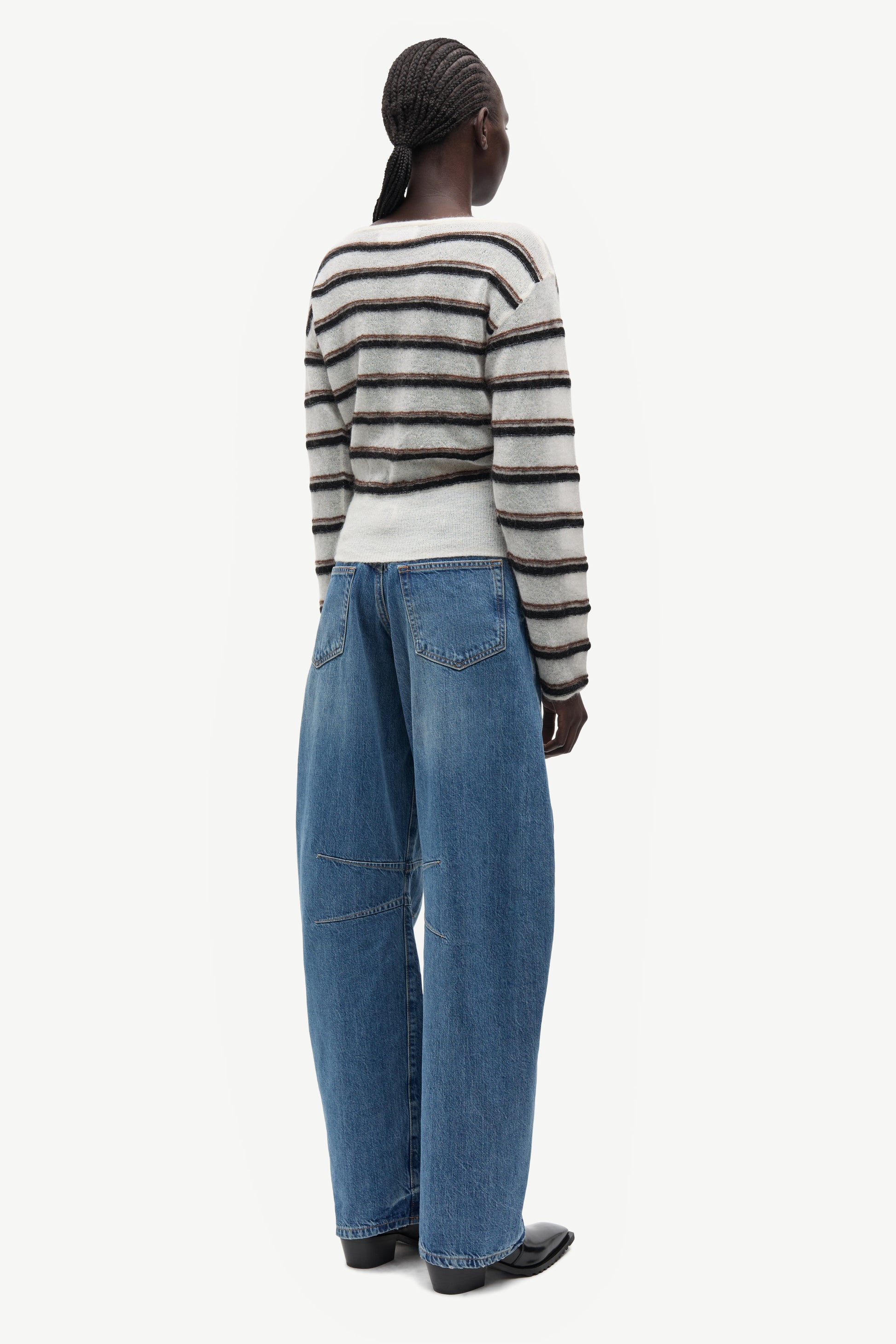 model wearing striped boat neck jumper and jeans on white background rear view