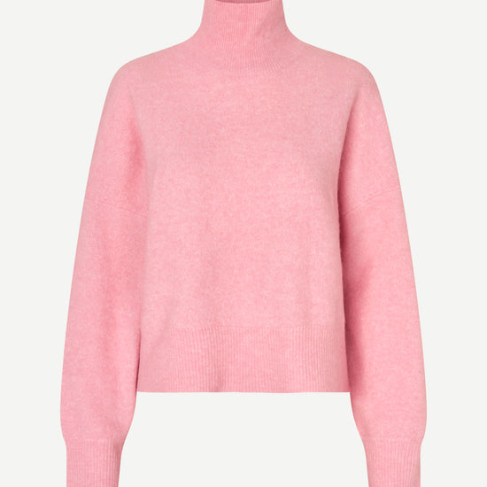 A light pink knit turtleneck sweater displayed on a clean, light gray background.