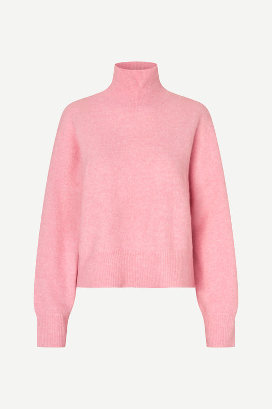 A light pink knit turtleneck sweater displayed on a clean, light gray background.
