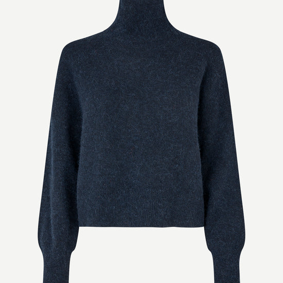 A dark navy blue knit turtleneck sweater with long balloon sleeves, shown on a plain light gray background.