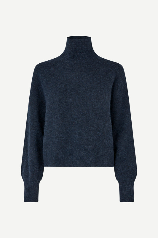 A dark navy blue knit turtleneck sweater with long balloon sleeves, shown on a plain light gray background.