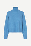 A light blue knit turtleneck sweater with long sleeves and ribbed cuffs, displayed on a clean, light off-white background.