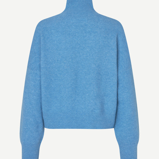 A light blue knit mock neck sweater shown from the back, featuring long sleeves and ribbed cuffs and hem, set against a plain off-white background.