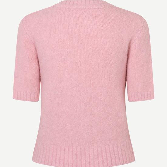 A light pink short-sleeve knit sweater shown from the back, featuring ribbed collar, cuffs, and hem, on a plain light gray background.
