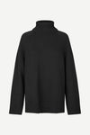 A black ribbed-knit turtleneck sweater with raglan sleeves, shown against a plain light gray background.
