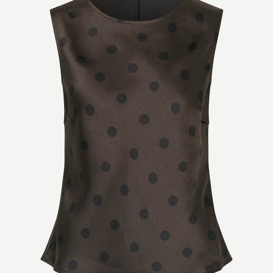 Brown sleeveless top with black polka dots on a white background