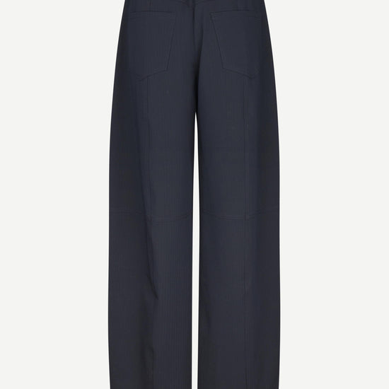 A pair of dark navy wide-leg trousers shown from the back on a light gray background.