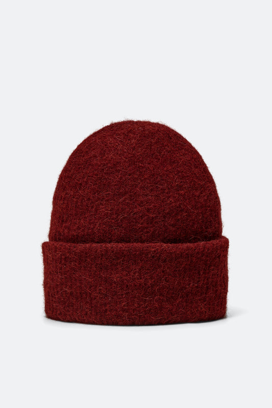 A dark red knit beanie hat with a folded cuff, shown against a plain light gray background.