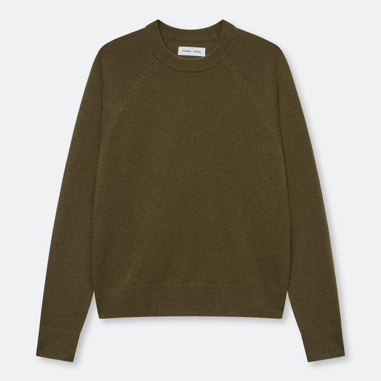 An olive green crewneck sweater with raglan sleeves, laid flat against a light gray background.