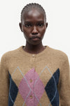 woman wearing brown pink and blue argyle cardigan on white background close up 