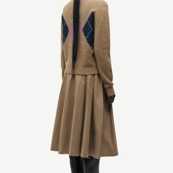 woman wearing brown pink and blue argyle cardigan on white background rear view