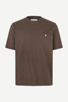 A brown short-sleeve crewneck t-shirt with a small white embroidered logo on the left chest, displayed on a clean off-white background.