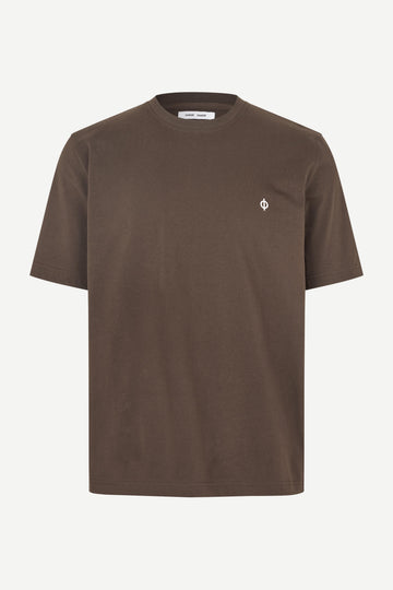 A brown short-sleeve crewneck t-shirt with a small white embroidered logo on the left chest, displayed on a clean off-white background.