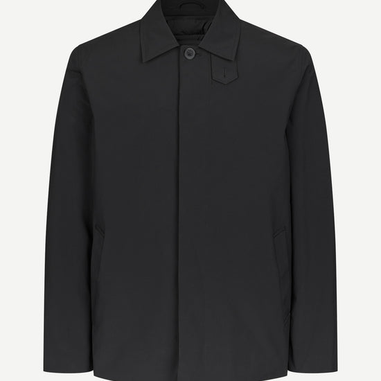 A black long-sleeve utility jacket with a pointed collar and a single button closure, displayed on a clean, light gray background.