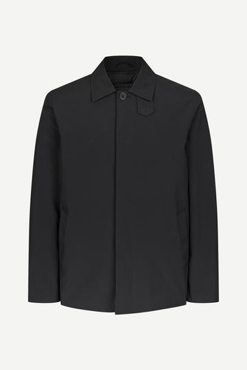 A black long-sleeve utility jacket with a pointed collar and a single button closure, displayed on a clean, light gray background.