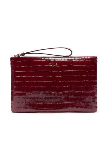 A deep burgundy crocodile-embossed leather clutch with a wristlet strap and a small gold-tone logo on the front, set against a plain white background.