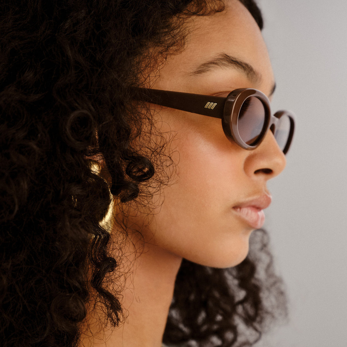 Person wearing sunglasses with a neutral background