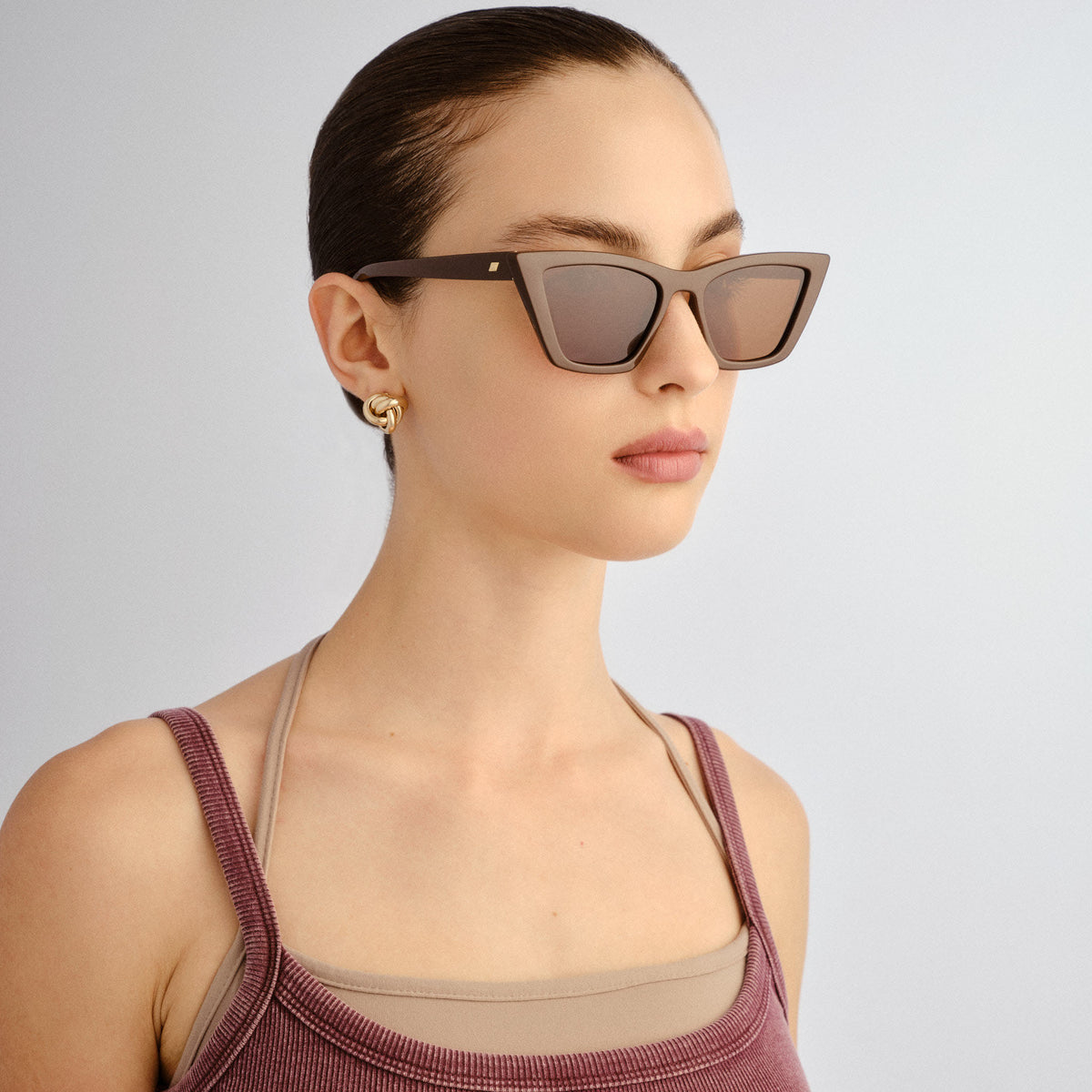 Woman wearing sunglasses with a plain background