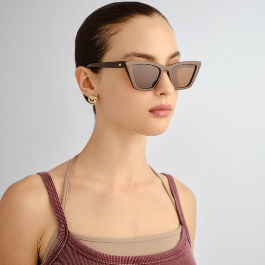 Woman wearing sunglasses with a plain background