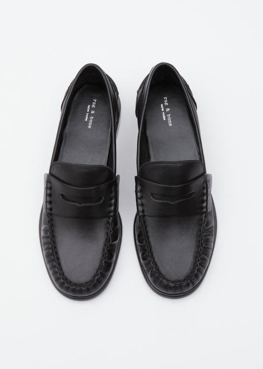 A pair of black leather penny loafers with braided detailing around the sole, photographed from a top-down perspective on a clean white background.