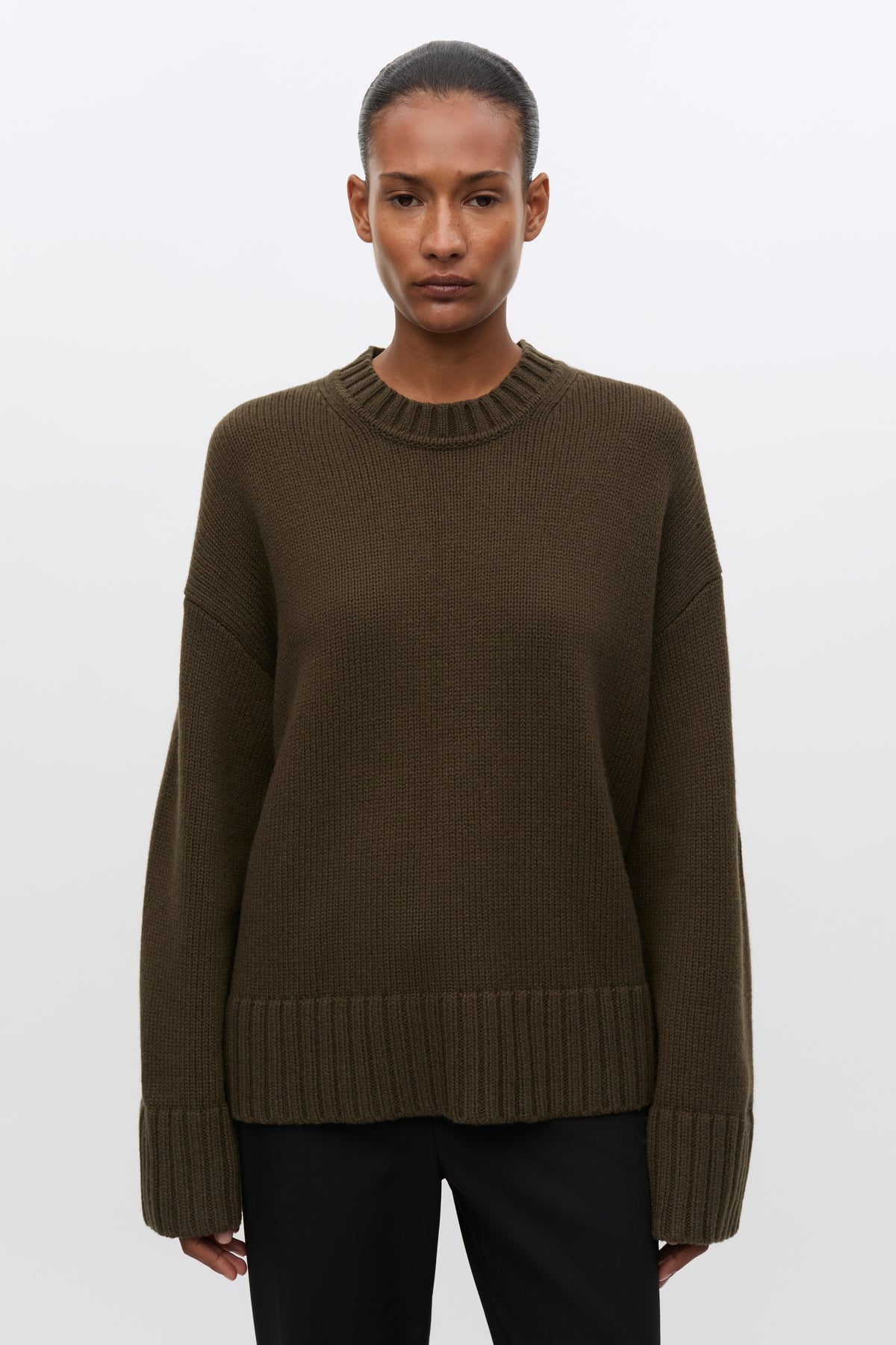 Woman wearing brown sweatshirt and black jeans