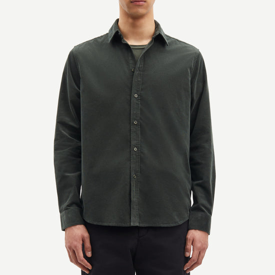 Man wearing a dark green button-up shirt over a gray t-shirt on a white background from Samsoe Samsoe