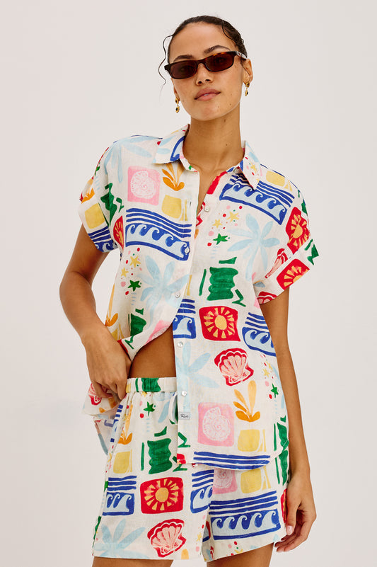 Woman wearing a colorful patterned outfit on a white background
