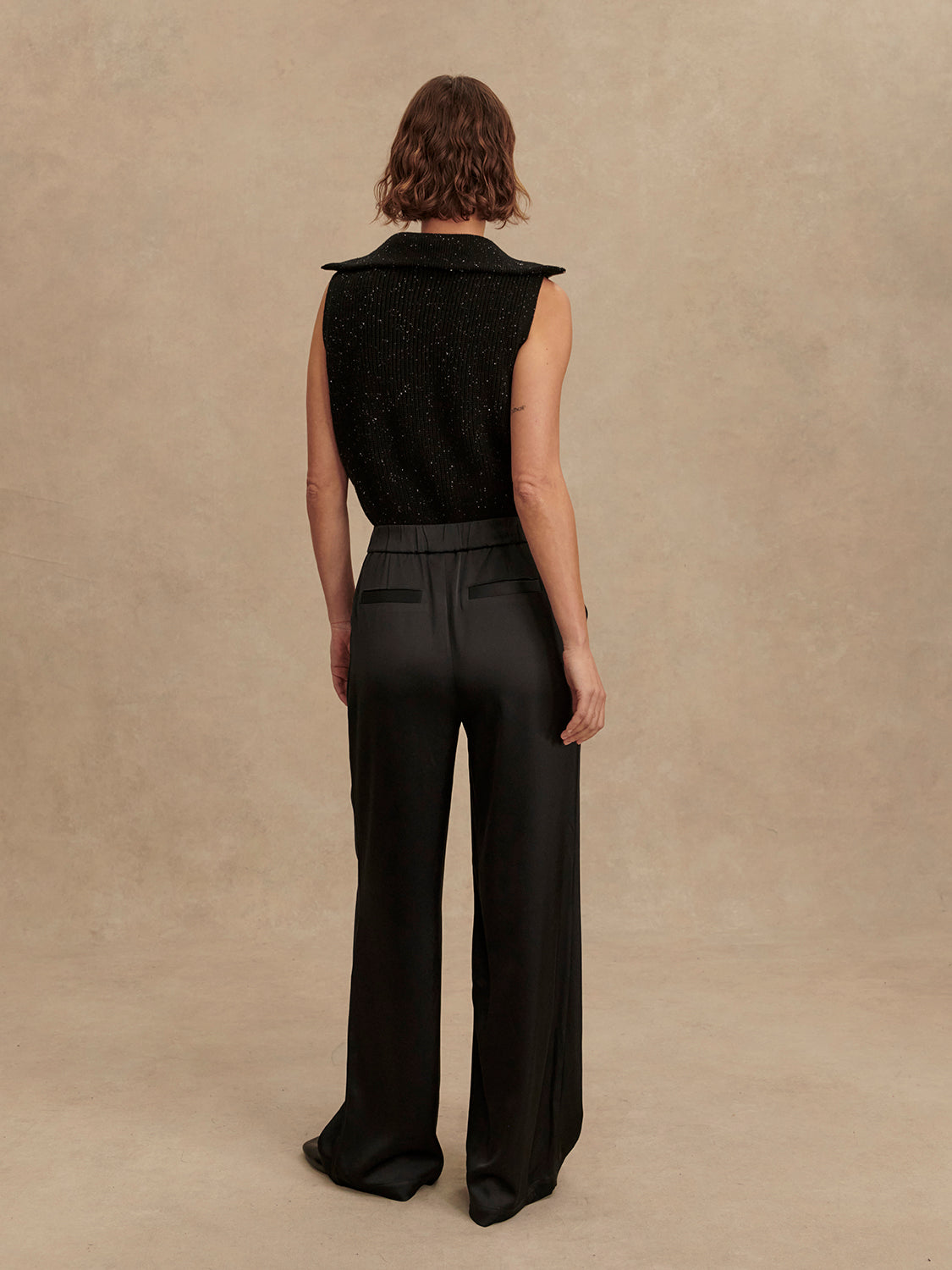 wide leg black viscose trousers with pleated front and side pockets rear view