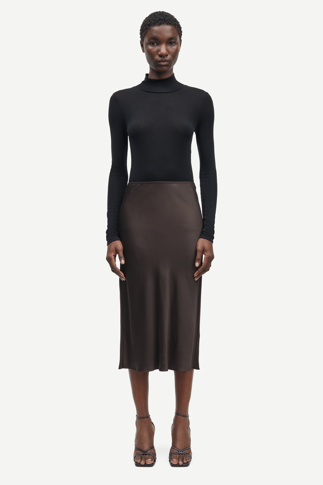Short mid length satin slip skirt in chocolate brown from samsoe samsoe model shot