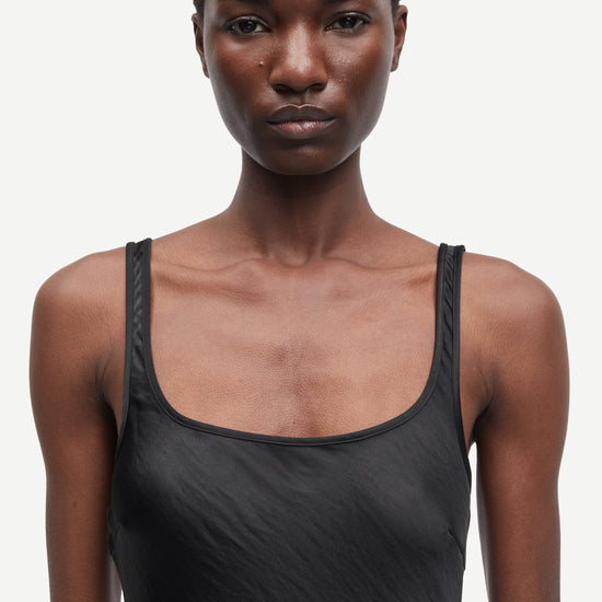 black slip dress with wide straps and figure hugging fit from samsoe samsoe close up