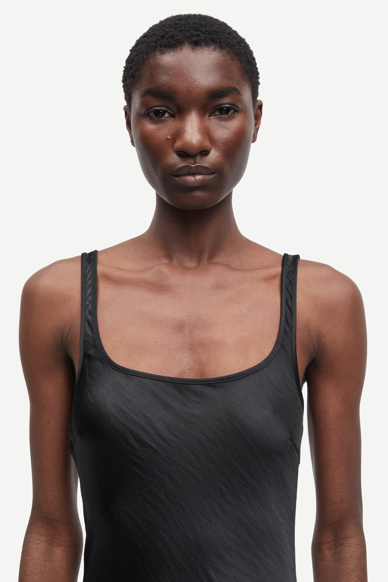 black slip dress with wide straps and figure hugging fit from samsoe samsoe close up